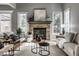Inviting living room with stone fireplace, neutral furniture, and abundant natural light from large windows at 1805 Braeburn Dr, Carmel, IN 46032