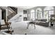 Bright living room with large arched windows, a gray sofa, and a staircase with wooden railing at 1805 Braeburn Dr, Carmel, IN 46032