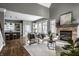Open-concept living room with modern furniture, stone fireplace, and kitchen island in the background at 1805 Braeburn Dr, Carmel, IN 46032
