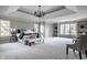 Spacious main bedroom featuring tray ceiling, sitting area, built-in shelving and large windows at 1805 Braeburn Dr, Carmel, IN 46032