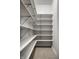 Walk in pantry with many white shelves, tiled floor, and accessible electrical outlet at 1805 Braeburn Dr, Carmel, IN 46032