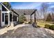 Large patio with stone pavers, a pergola, and manicured landscaping, offering outdoor living space at 1805 Braeburn Dr, Carmel, IN 46032