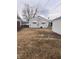 Spacious backyard with detached garage and white siding with mature trees at 1843 Bauer Rd, Indianapolis, IN 46218