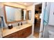 Bright bathroom with a wooden vanity, dual sinks, and an open doorway to the bedroom at 1939 Crystal Bay E Dr, Plainfield, IN 46168