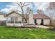 Exterior rear view of a charming home, with a sunroom, lawn, and mature trees at 2020 Cross Willow Ln, Indianapolis, IN 46239