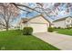 Garage with an extended driveway framed by a green lawn and garden beds, offering ample parking and curb appeal at 2020 Cross Willow Ln, Indianapolis, IN 46239