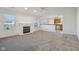 Bright living room with a cozy fireplace and neutral carpet, flowing into the kitchen at 2020 Cross Willow Ln, Indianapolis, IN 46239