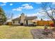 Spacious backyard with a lush green lawn, patio seating area, wooden fence, and mature trees at 2130 Crossford Way, Indianapolis, IN 46234