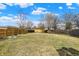 Large grassy backyard featuring a wooden fence and mature trees, ideal for outdoor activities and privacy at 2130 Crossford Way, Indianapolis, IN 46234
