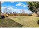 Spacious backyard with wooden fence, patio furniture, grill and mature trees on an overcast, bright day at 2130 Crossford Way, Indianapolis, IN 46234