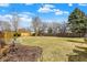 Expansive backyard featuring a mix of green lawn and mature trees with a partial view of a wooden fence at 2130 Crossford Way, Indianapolis, IN 46234