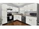 Bright and modern kitchen featuring white cabinets, stainless steel appliances, and hardwood floors at 2130 Crossford Way, Indianapolis, IN 46234
