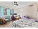 Bright bedroom with a patterned bedspread, window with curtains, desk, chair, and ceiling fan at 2165 Plantation Ln, Martinsville, IN 46151