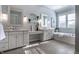 Elegant bathroom featuring double vanities, a soaking tub, tile floors, and decorative mirrors at 2274 Finchley Rd, Carmel, IN 46032