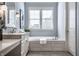 Bright bathroom features a soaking tub with tile surround and large window at 2274 Finchley Rd, Carmel, IN 46032