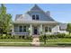 Charming home showcasing a covered porch, lush landscaping, and a stone chimney at 2274 Finchley Rd, Carmel, IN 46032