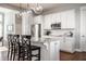 Charming kitchen with an island, seating, stainless steel appliances, white cabinets, granite counters, and pendant lighting at 2274 Finchley Rd, Carmel, IN 46032