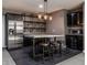 Basement bar area with tile flooring, bar seating, stainless steel fridge, and custom shelving at 2274 Finchley Rd, Carmel, IN 46032