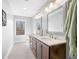 Bright bathroom featuring double sinks, vanity with granite countertops, and large framed mirrors at 2688 S Oscar Ct, Morgantown, IN 46160