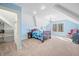 This bedroom features blue walls, an elegant chandelier, and large windows that let in plenty of natural light at 2688 S Oscar Ct, Morgantown, IN 46160