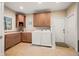 Well-equipped laundry room with washer, dryer, and wooden cabinets, with tile flooring and natural light at 2688 S Oscar Ct, Morgantown, IN 46160
