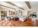 A large open living room featuring wood floors, beams, and a doorway to a music room with a piano at 2688 S Oscar Ct, Morgantown, IN 46160