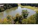 Picturesque view of a serene pond surrounded by lush greenery and mature trees at 2688 S Oscar Ct, Morgantown, IN 46160