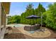Inviting backyard patio with a relaxing spa, an umbrella shaded seating area, and verdant landscaping at 286 S Woodridge Dr, Pittsboro, IN 46167