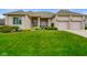 Well-manicured front lawn and exterior of home with 3-car garage and mature landscaping at 286 S Woodridge Dr, Pittsboro, IN 46167