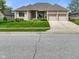 A beautifully landscaped single-story home with a well-manicured lawn and a three-car garage at 286 S Woodridge Dr, Pittsboro, IN 46167