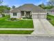 A beautifully landscaped single-story home with a well-manicured lawn and a three-car garage at 286 S Woodridge Dr, Pittsboro, IN 46167