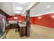 The kitchen features a breakfast bar, red walls, and hardwood floors at 286 S Woodridge Dr, Pittsboro, IN 46167