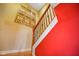 A staircase ascends past tan and red walls, decorated with decorative metal wall art at 286 S Woodridge Dr, Pittsboro, IN 46167