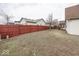 Fenced back yard with grass, mature tree, and back deck at 2888 Prairie Stream Way, Columbus, IN 47203