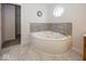 Bathroom featuring corner tub and marble floor and walls at 2888 Prairie Stream Way, Columbus, IN 47203