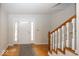 Inviting foyer with hardwood floors, a staircase with white spindles, and a welcoming front door at 2888 Prairie Stream Way, Columbus, IN 47203
