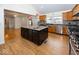 Open kitchen with an island, stainless steel appliances, and hardwood floors, perfect for entertaining at 2888 Prairie Stream Way, Columbus, IN 47203