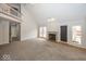 Bright living room with a fireplace, high ceilings, and a view of the upper level loft at 2888 Prairie Stream Way, Columbus, IN 47203