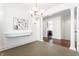Bright dining room featuring a modern chandelier, wall decor and an open floor plan leading to the kitchen at 3560 Cardinal Way, Carmel, IN 46074