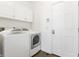 Bright laundry room featuring a white washer and dryer, white cabinets, and a white entry door at 3560 Cardinal Way, Carmel, IN 46074