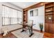Cozy home office with wood built-in shelving, hardwood floors, a large window, and a decorative rug at 3560 Cardinal Way, Carmel, IN 46074