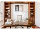 Close up of home office with wood built-in shelving, a decorative rug, and a dark wood desk at 3560 Cardinal Way, Carmel, IN 46074