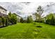 Lush green backyard with mature trees, a playset, and a view of the home's back exterior at 3905 Pelham Rd, Carmel, IN 46074