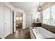 A relaxing bathroom showcases a soaking tub with a stylish chandelier and window at 3905 Pelham Rd, Carmel, IN 46074