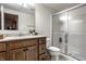 Bathroom featuring a wood vanity, large mirror, sink, toilet, and glass shower enclosure at 3905 Pelham Rd, Carmel, IN 46074