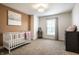 Bedroom with white crib, changing table, and accent wall at 3905 Pelham Rd, Carmel, IN 46074