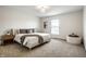 A bright bedroom with a large bed and neutral tones, and a window that lets in natural light at 3905 Pelham Rd, Carmel, IN 46074