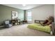 bedroom with a minimalist bed, gray armchair, and a large window that provides lots of natural light at 3905 Pelham Rd, Carmel, IN 46074