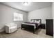 Bright bedroom with a comfortable bed, a chair, a window, and a dark dresser at 3905 Pelham Rd, Carmel, IN 46074