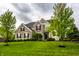 Beautiful two-story brick home with a well-manicured lawn and mature trees at 3905 Pelham Rd, Carmel, IN 46074